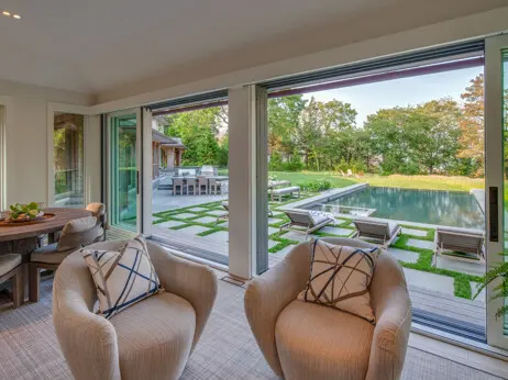 Pool house living space with full-height sliding doors with steps out to the pool area.