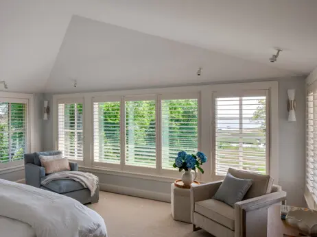 Second-floor bedroom looking out to the water. A calm interior palette.