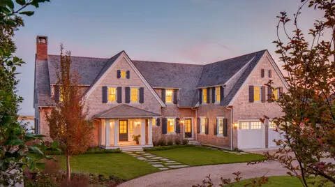 Cape Cod shingle-style home with a traditional, cottage-like front exterior.