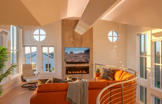 Sunlight pours into the second-floor sitting area that features a special light well and curved railing.