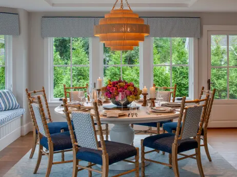 The dining space is set for a dinner party. A built-in window seat offers extra seating.
