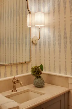 The powder room has beautiful wallpaper and finishes.